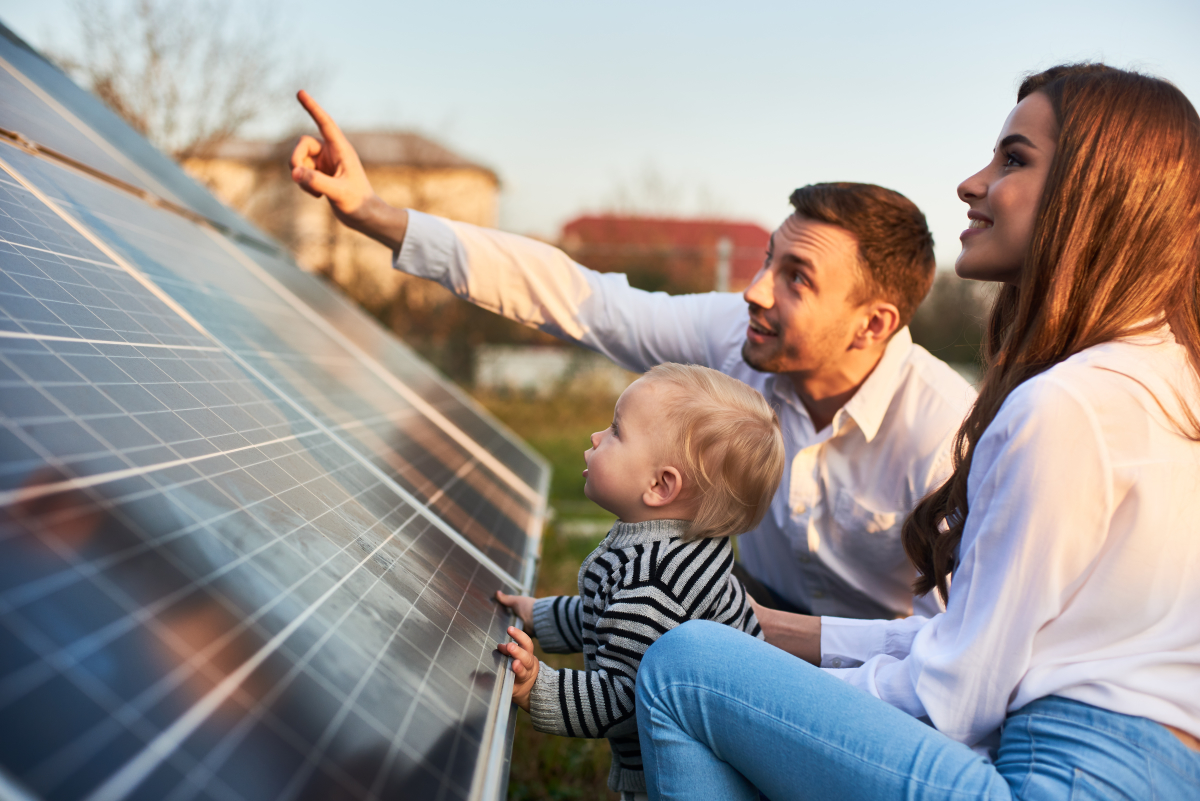 programme immobilier écologique – une famille devant des panneaux solaires photovoltaïques
